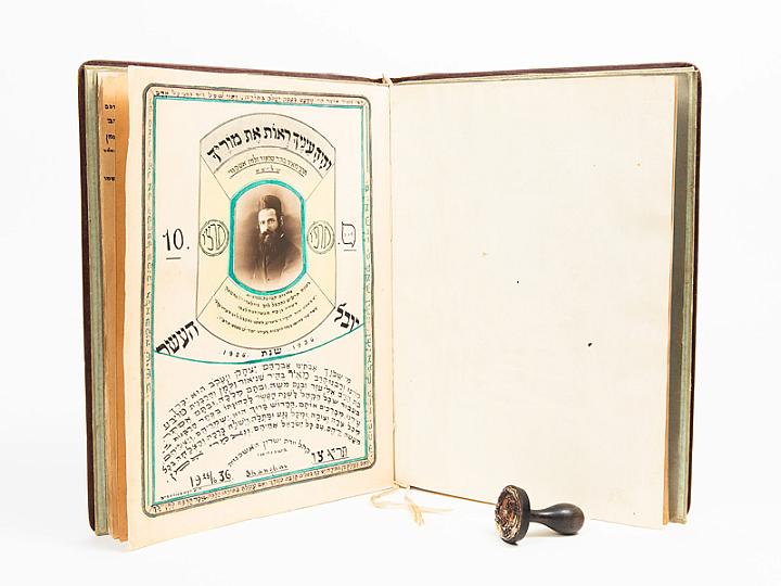 Marking stamp of Rabbi Meir Ashkenazi and handmade album presented to Rabbi Ashkenazi. Stamp is courtesy of Miriam Pogrow and notebook is courtesy of the Wilshanski family, shown here courtesy of Amud Aish Memorial Museum