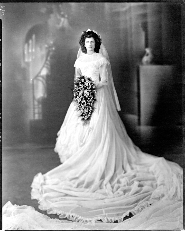 Wedding portrait of woman with dark hair, dressed in black with large cascading bouquet